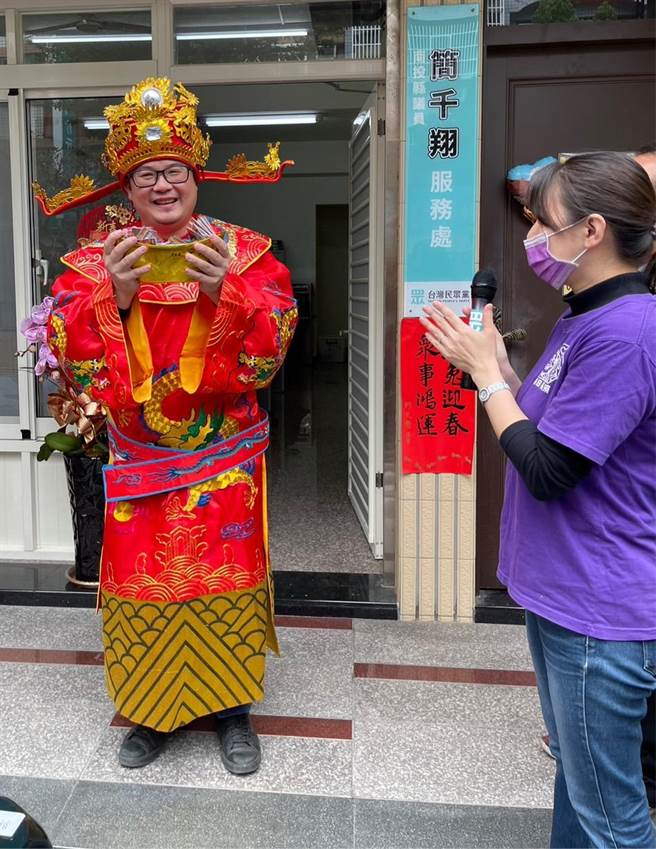 南投縣議員簡千翔扮演財神爺，發小紅包給民眾。（楊靜茹攝）