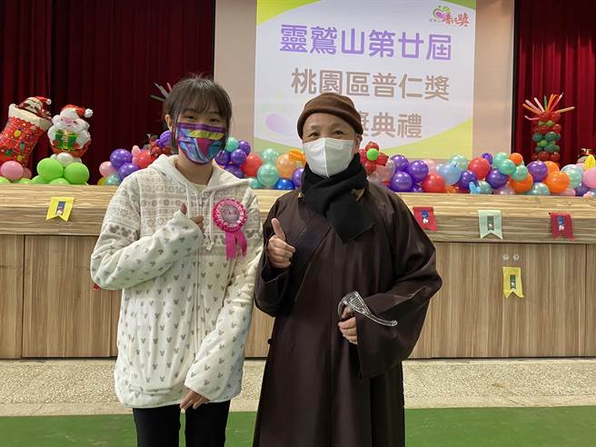 桃园讲堂执事妙慧法师（右）称讚龟山国中的王暐铃是个乐观有愿力的普仁小太阳。（灵鹫山佛教教团提供）