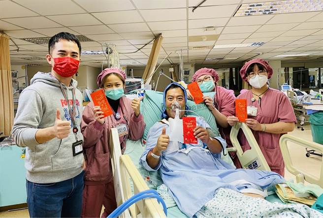 病患陈姓司机（中）春节前夕突发急重症紧急手术，杨智钧医师（左一）送上红包为病患加油。(光田医院提供)