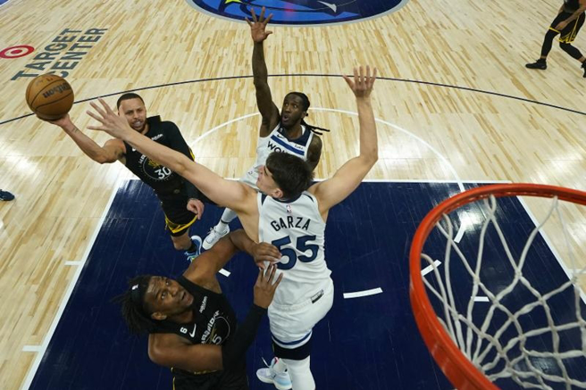 勇士队Stephen Curry(左)衝入灰狼阵中投篮。（美联社）