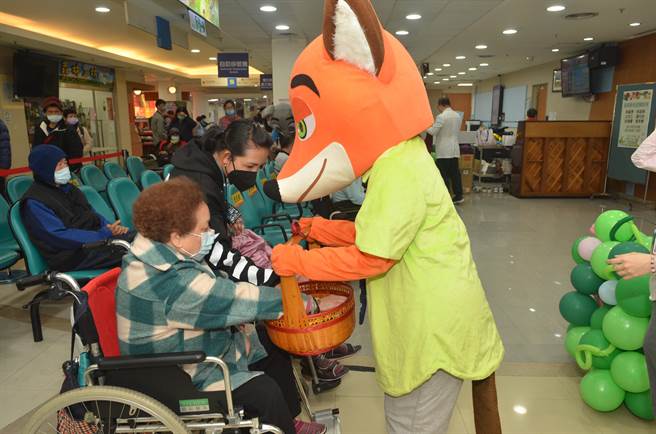 童综合医院新春团拜后，分送给民眾兔年特制祝福御守、寿桃与金币元宝巧克力等。（陈世宗摄）