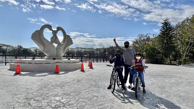 天鹅湖公园门面焕然一新，吸引不少家长带着小朋友来骑单车共游。（张毓翎摄）