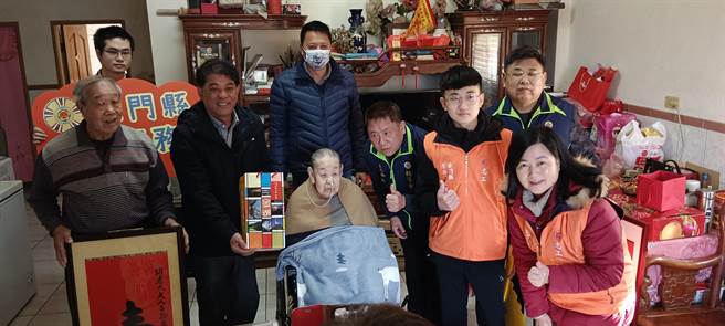 金门琼林里的百岁人瑞胡素贤(1排左3)寿诞，荣服处长游文勇(1排右3)、金湖镇长陈文顾(1排左2)、代表会主席蔡乃靖(2排中)与志工们一同前往祝寿。(图／金门荣服处提供)