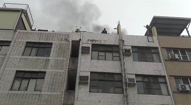 透天民宅楼顶浓烟不时窜出，救火的屋主一度受困，等待警消救援。（摘自南部记者爆料网）
