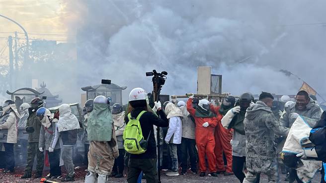台南一年一度重要的民俗盛事「盐水蜂炮」4日早上8点举行启炮仪式，不少信徒全身包紧紧抢先体验「犁蜂炮」。（张毓翎摄）