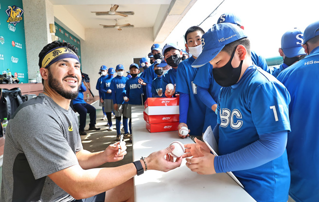 象魔力为韩国HBC俱乐部小球员签名。（中信兄弟提供）