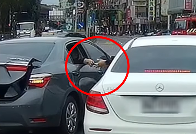一辆货车驾驶3日自国道三号下土城交流道时遇到砸车，涉嫌暴力砸车的轿车乘客于动手前，被拍到先递交不明物品给同行车辆。（翻摄自脸书《八卦村 - 行车纪录器影片上传中心》）