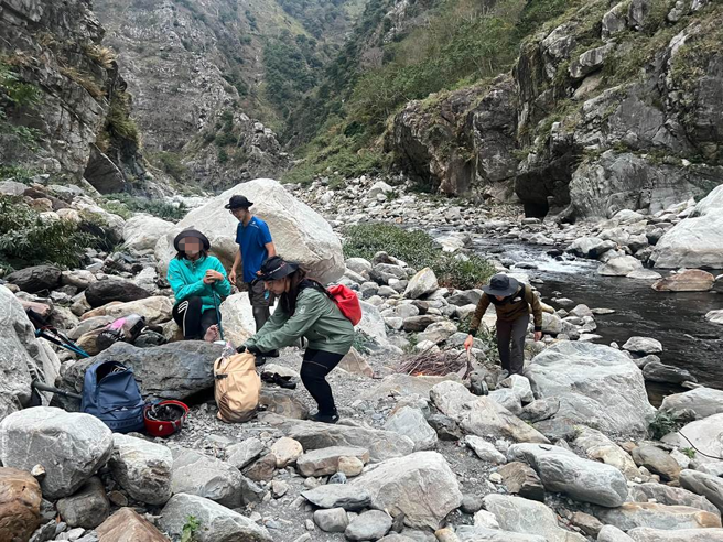 消防局搜救人员给予陈女弹绷包扎固定，并陪同伤者缓慢沿大甲溪河床，及下游入口处行进。(台中市消防局提供)