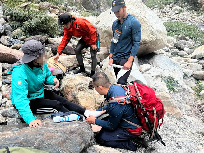 消防局搜救人员给予陈女弹绷包扎固定，并陪同伤者缓慢沿大甲溪河床，及下游入口处行进。(台中市消防局提供)