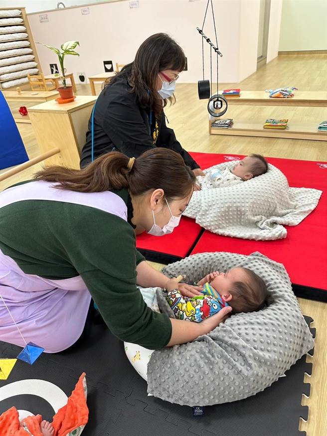 社会局长廖静芝与托育人员安抚幼儿的情形。（台中市政府提供）