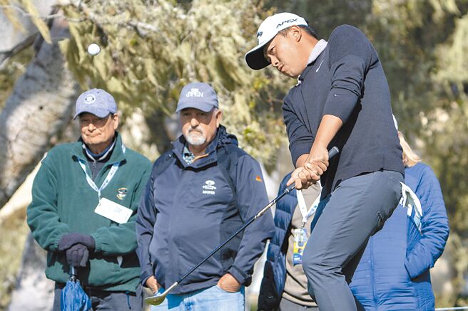 台湾选手俞俊安专注看着自己切出的小白球飞行方向。（路透）