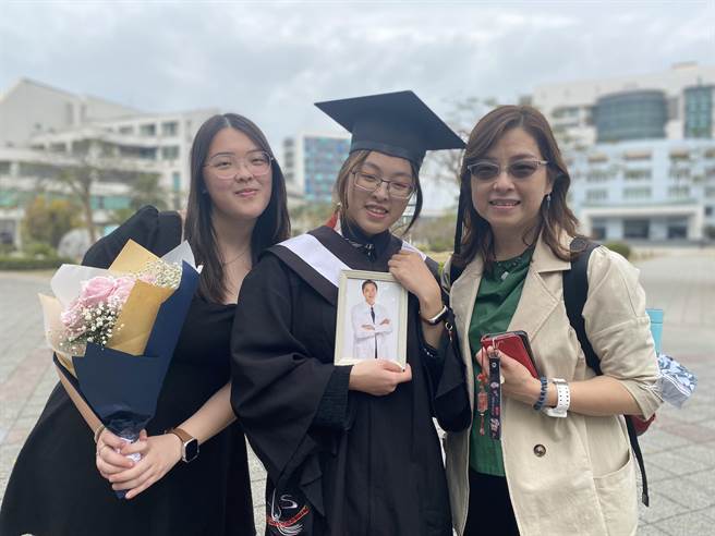 刘学蓉因丈夫病逝从护理转职殡葬业，女儿林芃岑(中)今年以优异成绩提早完成嘉南药理大学的学业，母女带着爸爸照片一起毕业。(曹婷婷摄)