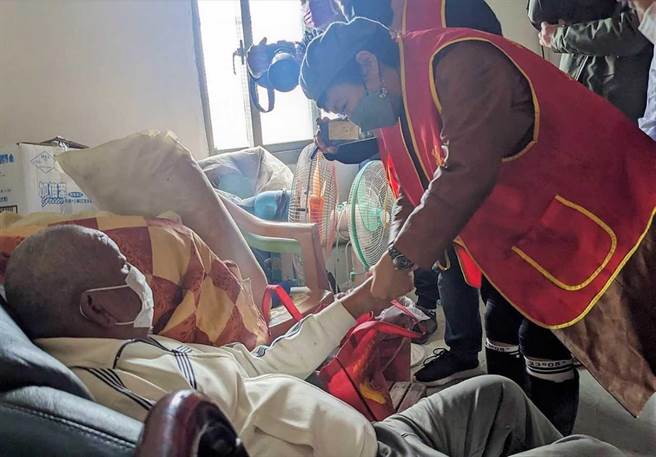 谢丽金（右）为独居阿公涂抹护手霜。（艾迪升传播提供）