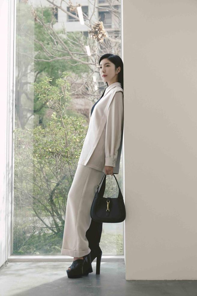 杨谨华以黑白拼接的俐落套装搭配黑色Jackie 1961小型肩背包，凸显其稳重的气质。(Gucci 提供)