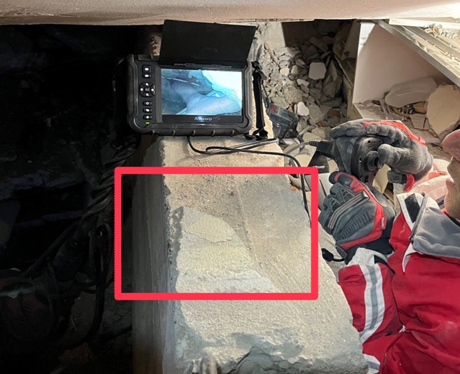 生存者「意识清楚可对话」，遭水泥柱压住露出下肢，透过摄影机看得相当清楚。(消防署提供)