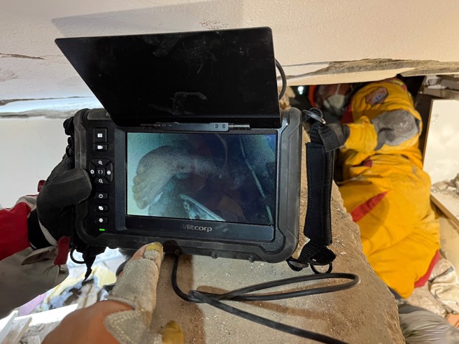 生存者下肢露出「意识清楚可对话」，搜救人员正破坏梁柱救人。(消防署提供)