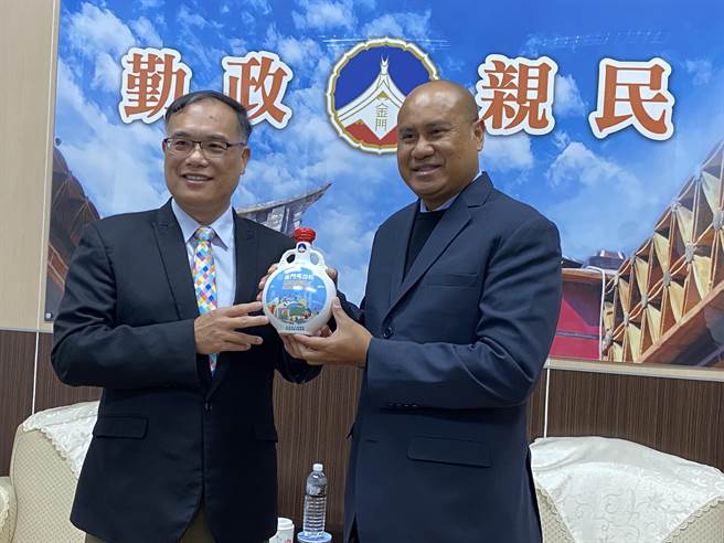 副县长李文良(左)致赠金门马拉松高粱纪念酒给帛琉观光部长提莫特柯尔(右)，也藉机行销金酒。(于家麒摄)