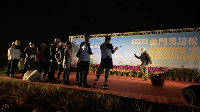 2023「金门马」竞赛组登场，天未亮跑者便陆续抵达会场排队拍照留念。（于家麒摄）
