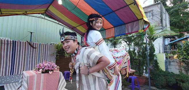 花蓮縣秀林鄉富世村可樂部落11日舉辦一場太魯閣族傳統婚禮，新郎尤黃柏碩以「巴卡（paga）」方式，揹著新娘林怡妏走入婚禮會場，象徵男方往後有能力讓女方過好日子。（民眾提供／羅亦晽花蓮傳真）