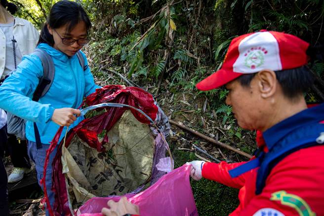 参加净山健行活动的民眾手持夹子、长勾及垃圾袋，沿途捡拾步道上的垃圾。（新北市观旅局提供）