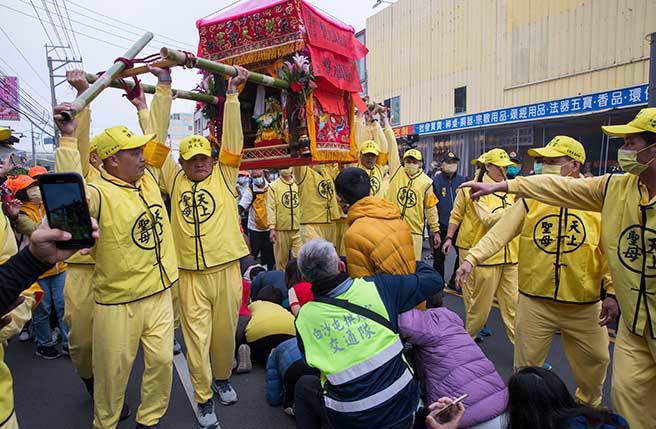 苗栗通霄白沙屯拱天宮媽祖往北港進香活動12日凌晨起駕，據主辦單位統計，今年吸引逾11萬信徒隨行，下午起駕後沿途有大批信徒跪臥在馬路上鑽轎腳，碰到臥床或行動不便的信徒，轎班還特地抬高鑾轎跨越。（黃子明攝）