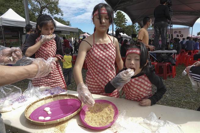 参加「玩味大同」观光产业推广活动的泰雅族小女生品尝现场擣出的大米麻糬。（黄子明摄）