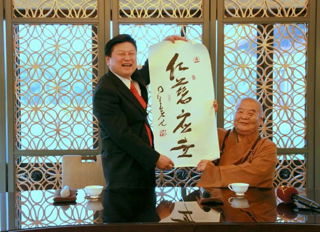 大師贈一筆字墨寶「仁慈應世」給傅崐萁，傅縣長伉儷回贈大師圍巾，親手為大師圍上。(戴志揚翻攝)