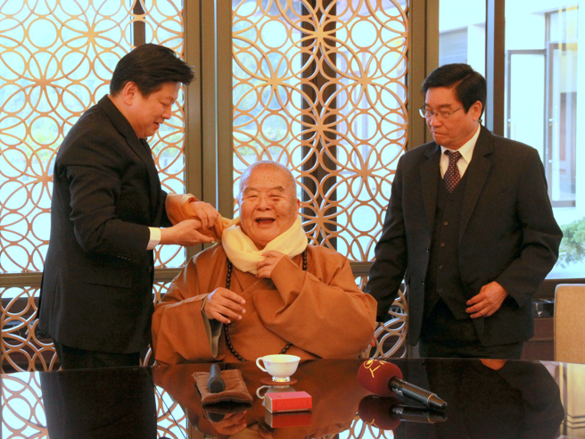 大師贈一筆字墨寶「仁慈應世」給傅崐萁，傅縣長伉儷回贈大師圍巾，親手為大師圍上。(戴志揚翻攝)