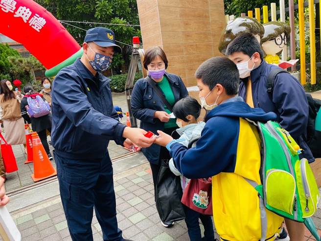 北市警中山分局執行護童專案，分局長陳金城（左一）發放給學童宣導小物。（警方提供）