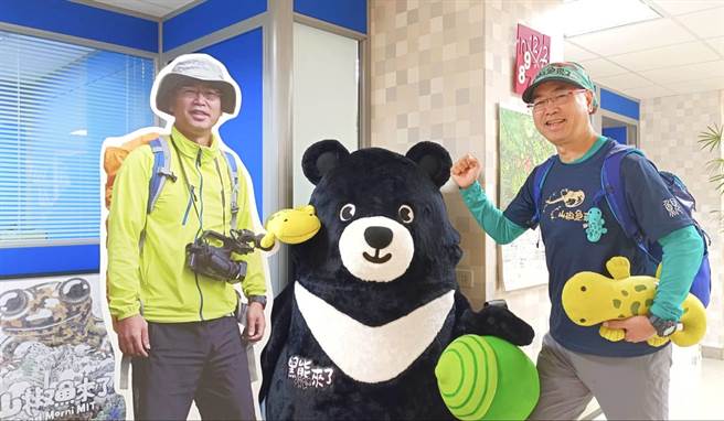 麦觉明导演抱着《山椒鱼来了》小鲵娃娃与《黑熊来了》熊吉拉合影。（大麦影像传播工作室提供）