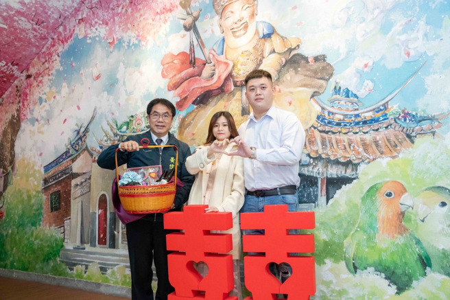 黄伟哲为鼓励情侣在台南许下终生大事，今日特地向登记结婚的小俩口致赠好礼，并宣布多项让年轻人乐于生育的政策。(戴志扬翻摄)