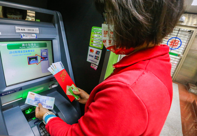 全国12家金融机构共2万4,922台ATM，将可提领六千元现金红包。图为民眾在提款机提领现金。（中时资料照／粘耿豪摄）
