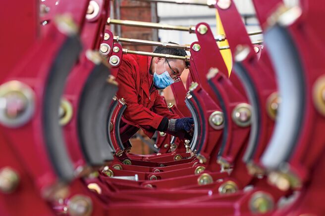 大陆今年「两会」将于3月初召开并订出全年GDP成长目标。图为在江西省丰城市一制动器生产公司，员工在生产车间赶制外销产品。（新华社）