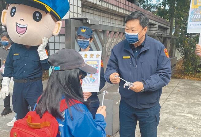 台中市警第三分局长吴铭渊（右）13日率家防官到国光国小校门口前为学童加油打气。（台中市警第三分局提供／张妍溱台中传真）