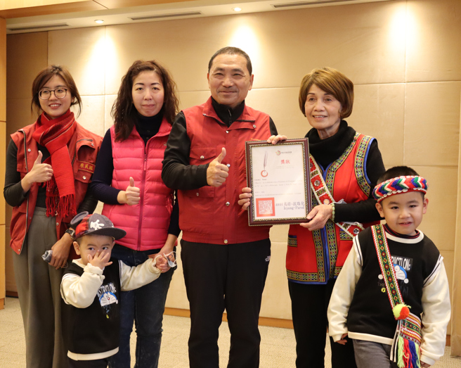 新北优良族语保母陈菊江(右二) 带孙献奖给市长侯友宜。图/新北市政府提供