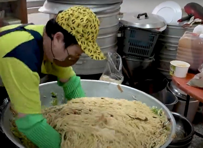 素食店老板在白沙屯妈祖进香遶境活动前不慎烫伤手，在祈求妈祖后，终于顺利用双手炒麵让香灯脚们能吃饱喝足再出发。（翻摄影片）