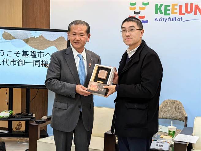 基隆市长谢国梁（右）与八代市长中村博生（左）热情地交换礼物，象徵双方友好情谊。（张志康摄）