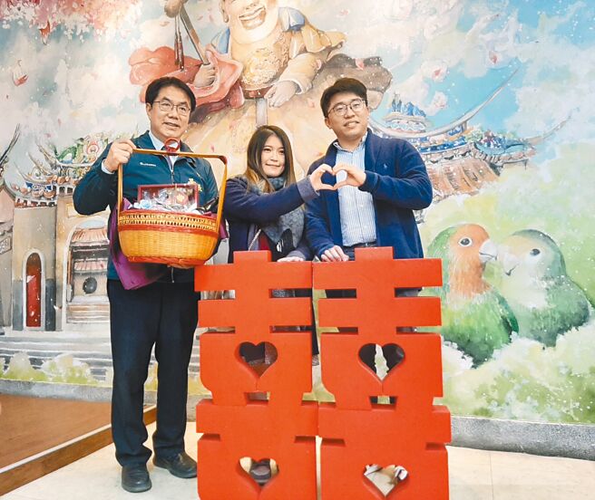 臺南市市长黄伟哲于情人节送出首波祝福礼，并推荐臺南婚纱秘境景点；图为黄市长赠送祝福礼予成田先生及钟小姐。图／臺南市观旅局提供