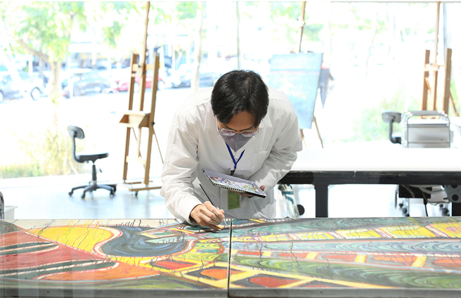 專業修復師細膩地修補畫家曾培堯的作品《生命694》。(攝影/Carter)