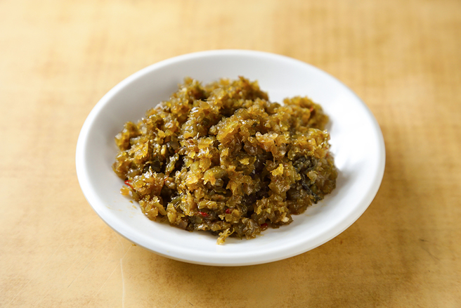 新百龄排骨大王的酸菜，经过水洗一整天，洗去化学加工物，口感新鲜甘甜、十分下饭，堪称便当的灵魂配角 。(摄影/Carter)