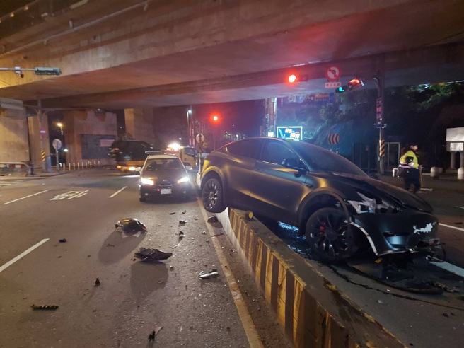 特斯拉自撞分隔岛车头毁 驾驶因酒驾烙跑 （简铭柱翻摄）