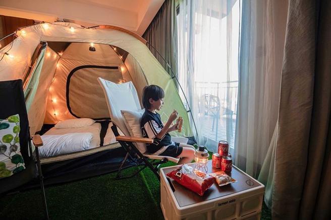 （福容淡水渔码店「露营主题房」，客房内铺草皮、顶级帐篷，非常有露营气息。图／福容淡水渔码店）