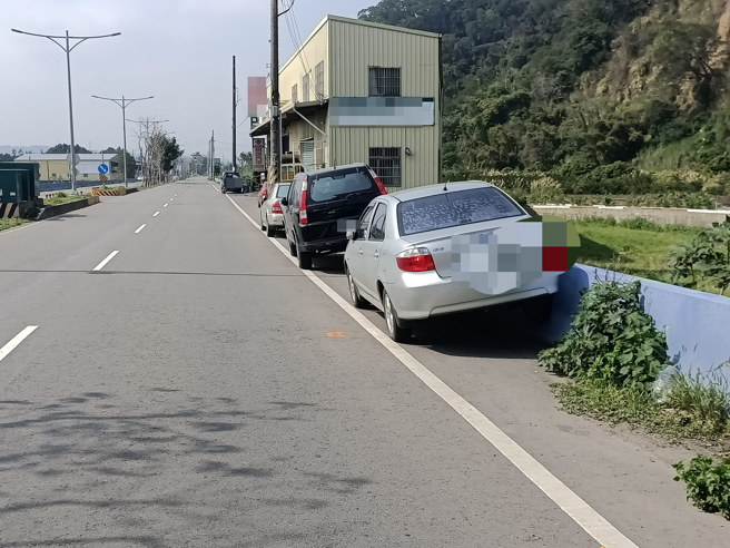 有2輛汽車因要路邊停車，但又怕車身超出白線太多，竟然將右側輪胎騎上護欄，有趣的行徑也被網友笑稱「應該都是被檢舉達人逼的」。（翻攝自臉書爆廢功社二館）