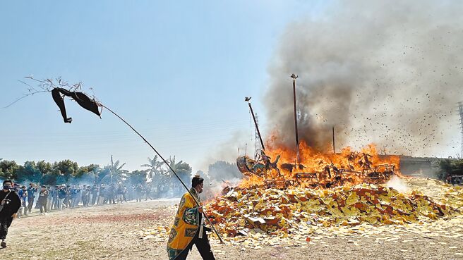 台南市佳里金唐殿昨日举行萧壠香科醮典「送王」烧王船仪式，王船烧起来那一刻，现场民眾抢拍精彩画面。（张毓翎摄）