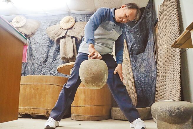 嘉义县阿里山乡丰山村民早年「转大人」必试的「石哑铃」重达20多公斤，要用5根手指抓起来非常不容易，挑战成功者实在少数。（吕妍庭摄）