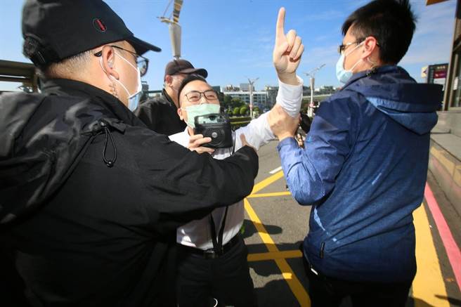 松山机场外有统派民眾向独派民眾呛声，由警方戒护离开。（张铠乙摄）