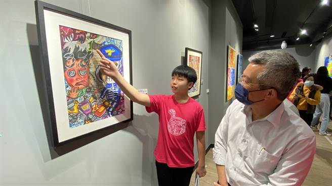 参与展出的同学详细的向金沙镇长吴有家(右)介绍自己的作品。(于家麒摄)