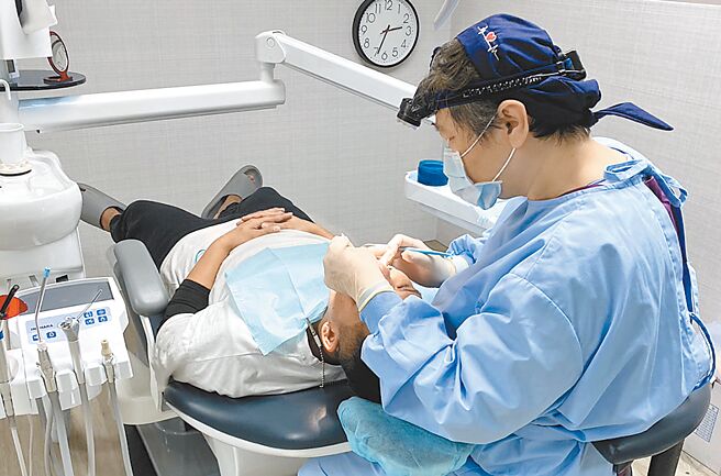 乌来区口腔医疗站牙医师为原住民长者评估装置假牙。（新北市原民局提供／陈慰慈新北传真）