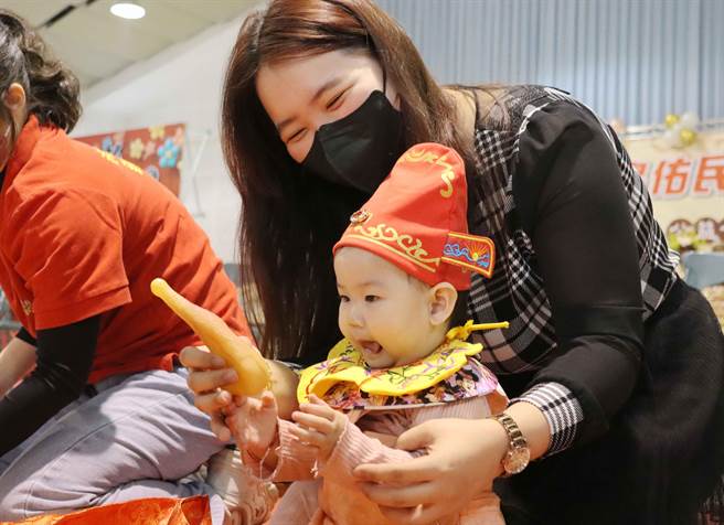 抓到鸡腿的宝宝都露出一副东西好吃模样，连妈妈都忍不住笑开了。（吕妍庭摄）