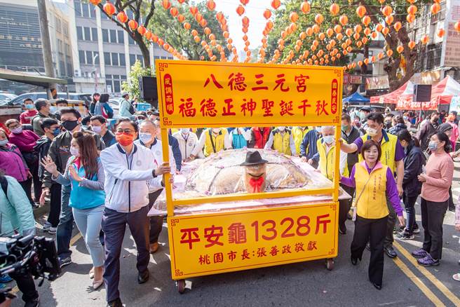 桃园市长张善政19日特别敬献重达1328斤的平安米糕龟和信眾分食。(蔡依珍摄)